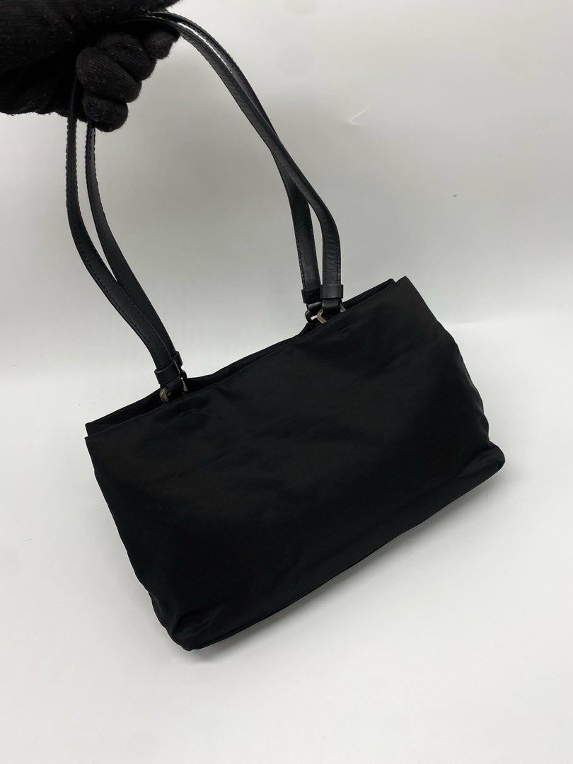 Prada Nylon Mini Tote Shoulder Bag (Category: Luxury Bags & Wallets) located in Marikina City. Submitted by closet.ar (Listing ID 1468813149, Image 3). Description: - Authentic Prada nylon shoulder bag in classic black - Dual black leather straps for comfortable wear - Silver-tone hardware featuring the iconic triangular logo plaque - Durable, structured, and perfect for everyday use - Includes original white Prada dust bag - Condition: Excellent