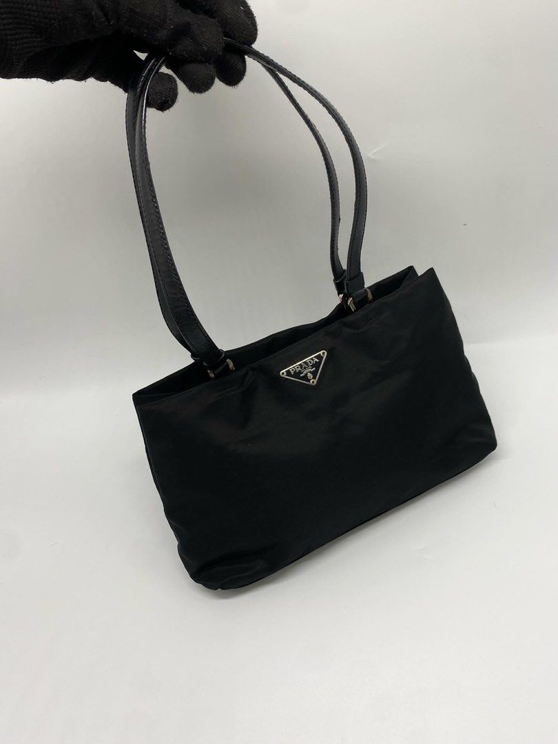 Prada Nylon Mini Tote Shoulder Bag (Category: Luxury Bags & Wallets) located in Marikina City. Submitted by closet.ar (Listing ID 1468813149, Image 2). Description: - Authentic Prada nylon shoulder bag in classic black - Dual black leather straps for comfortable wear - Silver-tone hardware featuring the iconic triangular logo plaque - Durable, structured, and perfect for everyday use - Includes original white Prada dust bag - Condition: Excellent