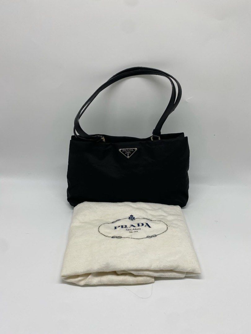 Prada Nylon Mini Tote Shoulder Bag (Category: Luxury Bags & Wallets) located in Marikina City. Submitted by closet.ar (Listing ID 1468813149, Image 1). Description: - Authentic Prada nylon shoulder bag in classic black - Dual black leather straps for comfortable wear - Silver-tone hardware featuring the iconic triangular logo plaque - Durable, structured, and perfect for everyday use - Includes original white Prada dust bag - Condition: Excellent