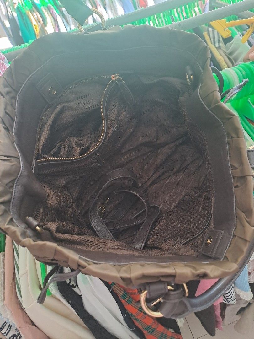 Prada Nylon Ruched Bag (Category: Luxury Bags & Wallets) located in Puerto Princesa. Submitted by jercksthriftph (Listing ID 1468928153, Image 3). Description: - Brand: Prada - Color: Rich brown - Material: Durable nylon with luxurious leather handles - Design: Stylish ruched exterior with iconic front logo plaque and matching leather key tag - Hardware: Elegant gold-tone accents - Interior: Signature Prada fabric lining with a convenient zippere