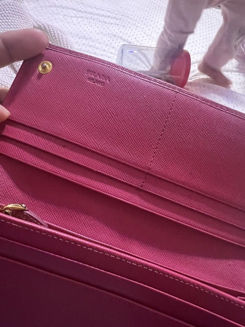 Prada Saffiano Flap Bow Wallet Pink (Category: Luxury Bags & Wallets) located in Manila. Submitted by asissaleh35322 (Listing ID 1468900745, Image 3). Description: - Brand: Prada - Material: Saffiano Leather - Color: Pink - Hardware: Gold-tone with front bow detail - Closure: Snap closure - Interior: Multiple card slots, compartments, and zipper coin pocket - Condition: Clean inside and out, minor wear around edges as shown in photos - Guaranteed