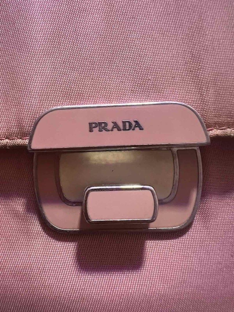 Prada Saffiano Leather Flap Wallet Pink (Category: Luxury Bags & Wallets) located in Manila. Submitted by asissaleh35322 (Listing ID 1468897765, Image 1). Description: - Authentic pink Prada wallet in durable Saffiano leather - Front metal lock clasp with engraved Prada branding - Interior includes multiple card slots, a bill compartment, and a coin pocket - Crafted in Italy (stamp visible inside) - Condition: Shows minor wear and scuffs on the e