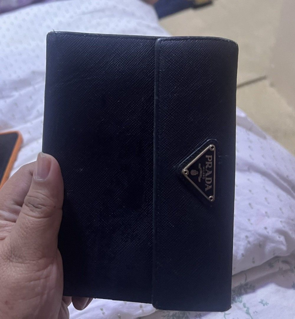 Prada Saffiano Lux Leather Trifold Wallet (Category: Luxury Bags & Wallets) located in Manila. Submitted by asissaleh35322 (Listing ID 1468889493, Image 2). Description: - Authentic Prada trifold wallet - Crafted from durable black Saffiano Lux leather - Iconic enamel triangle logo plaque on the front - Interior features multiple card slots, cash compartment, and coin pocket - Compact design, fits easily in any handbag super ganda authentic .