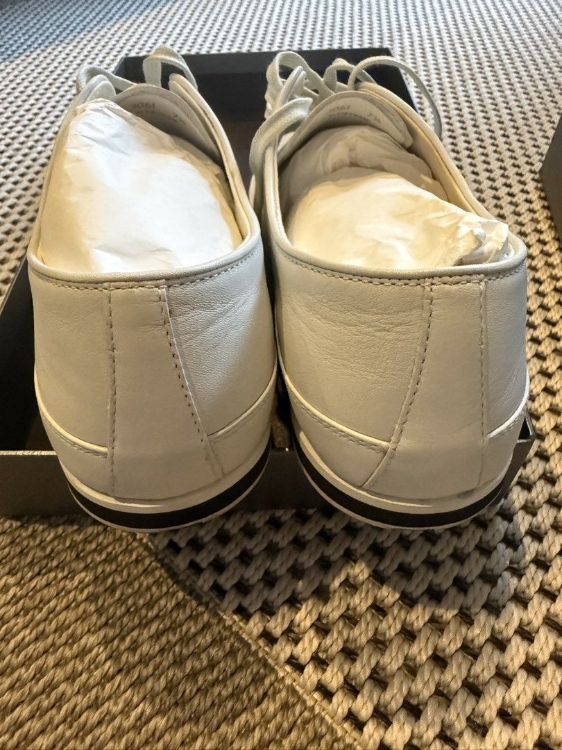 Prada White Leather Sneakers with Box (Category: Casual Shoes) located in Makati City. Submitted by marckyboy (Listing ID 1468748048, Image 3). Description: - Brand: Prada - Color: Crisp White - Material: Smooth premium leather - Design: Clean minimal aesthetic with classic lace-up front - Details: Flat rubber sole with black stripe detail and subtle debossed side logo - Inclusion: Comes inside original branded box with tissue paper - Condition: 