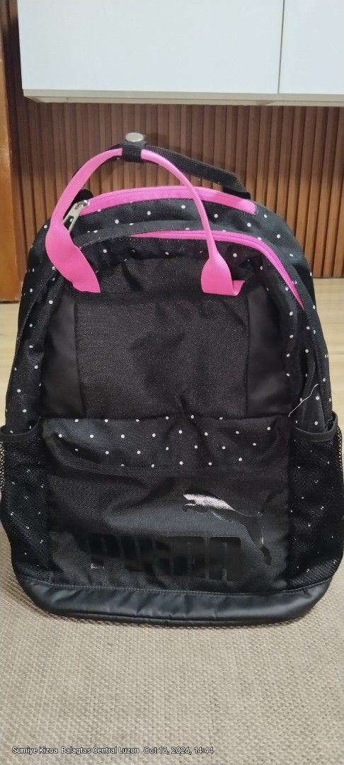 Puma Black and Pink Polka Dot Backpack (Category: Backpacks) located in Guiguinto. Submitted by ambershelb75728 (Listing ID 1468769899, Image 1). Description: - Brand: Puma - Design: Black with white polka dots and bright pink accents - Comfort: Dual top carry handles and adjustable padded shoulder straps - Storage: Main zippered compartment, front zippered pocket, and side mesh pockets - Interior: Vibrant pink lining with durable black base pane