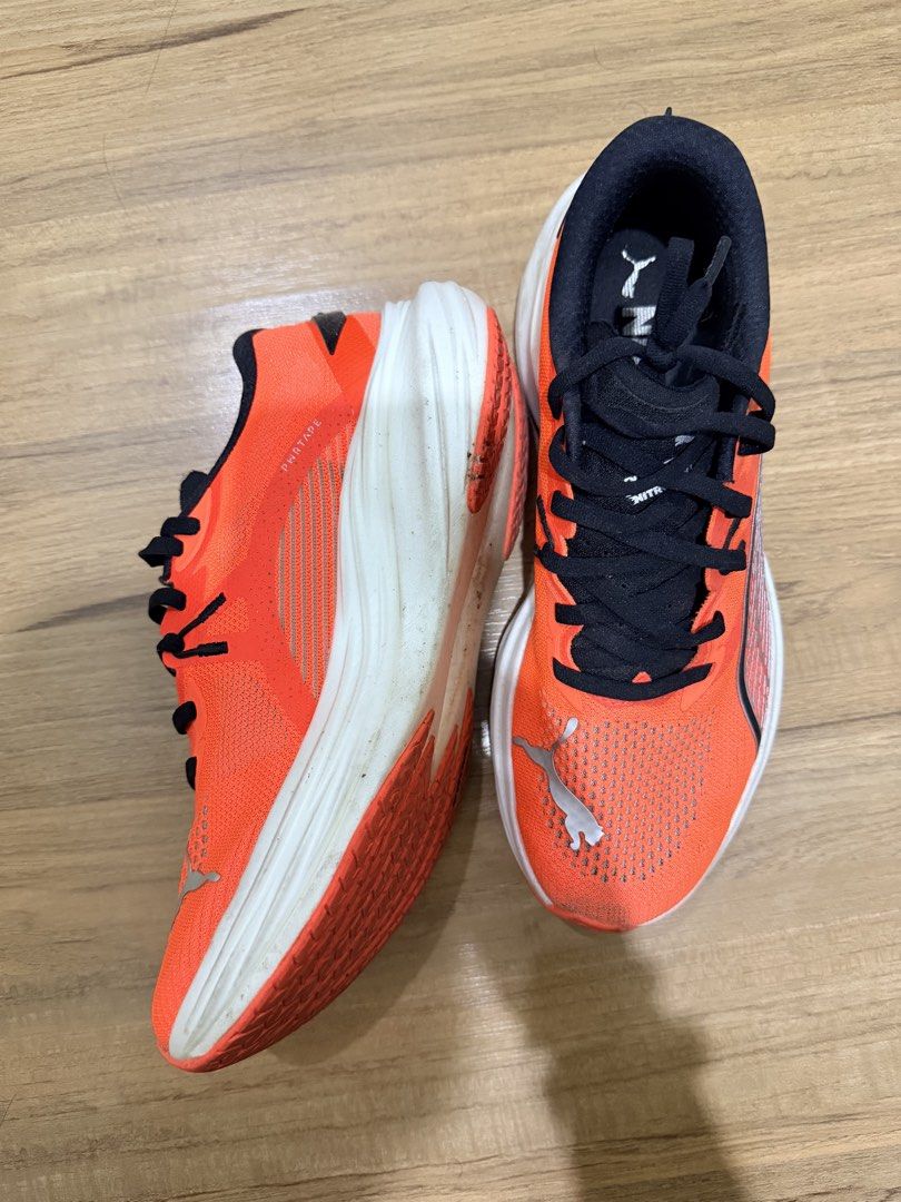 Puma Deviate Nitro Running Shoes Orange US 8 (Category: Sneakers) located in Makati City. Submitted by toneeann (Listing ID 1468855448, Image 2). Description: - Brand: Puma running shoes - Color: Bright orange with black laces and reflective silver branding - Size: US 8 / UK 7 / EUR 40.5 / CM 26 - Cushioning: White NITRO foam midsole for high-energy return - Outsole: Durable black rubber traction outsole - Condition: Minor dirt marks on the white