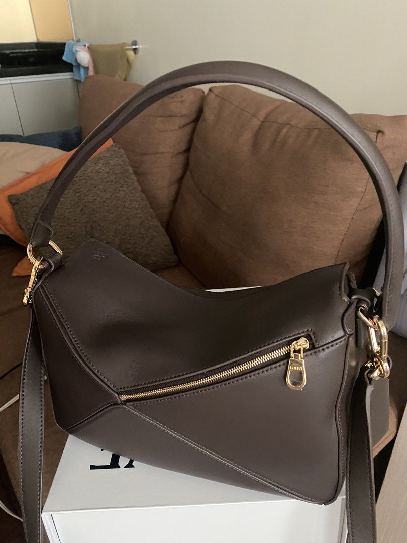 Puzzle Edge Bag in Dark Brown (Category: Cross-body Bags) located in Makati City. Submitted by dpjanssen (Listing ID 1468791539, Image 3). Description: - Puzzle Edge bag in dark brown leather - Signature geometric panel design with luxurious gold-tone hardware - Versatile styling with both a top handle and shoulder strap - Secure zip top closure and branded interior plaque - Includes white box - Perfect luxury everyday bag for work or weekend - s