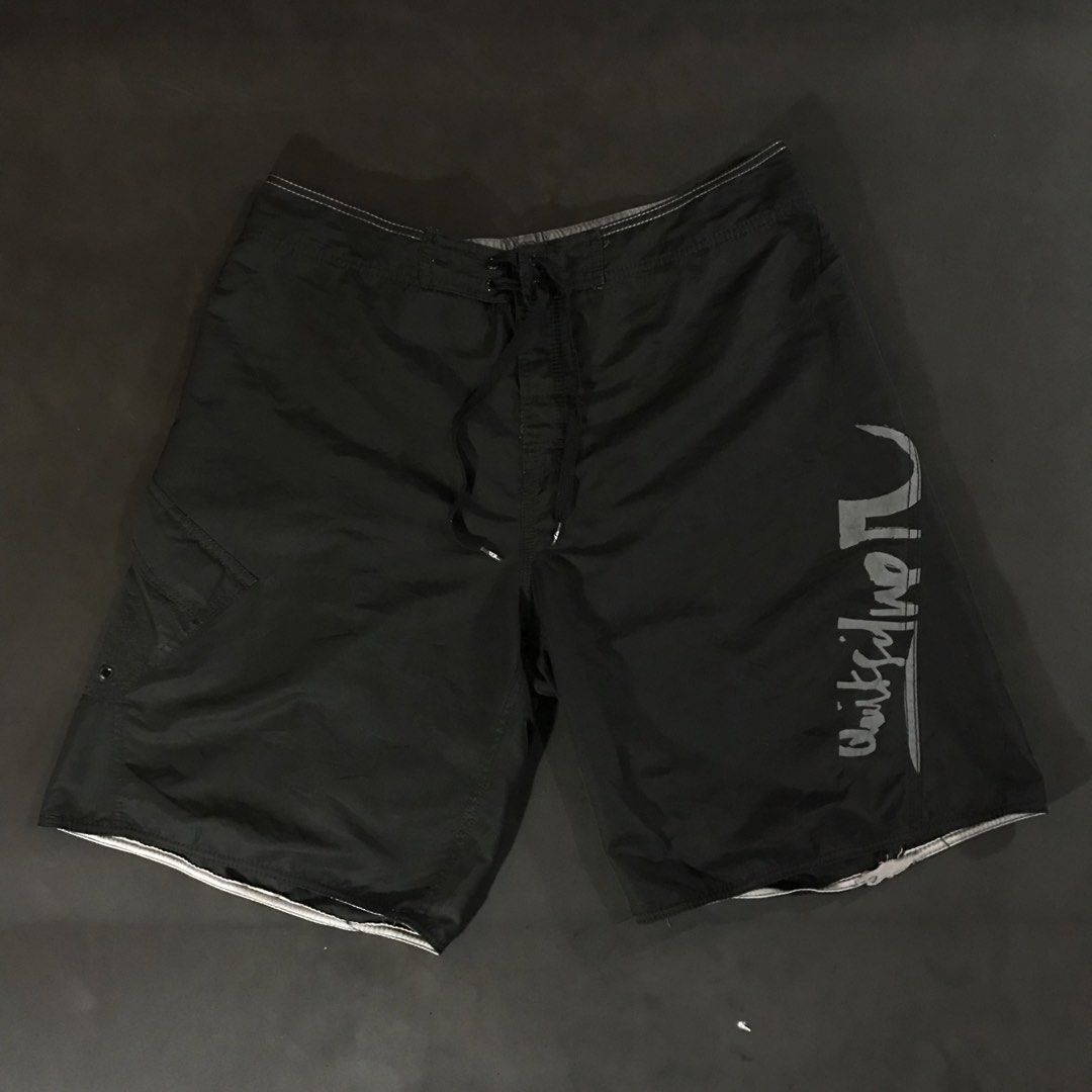Quiksilver Board Shorts (Category: Swim Trunks & Board Shorts) located in Manila. Submitted by a_aron.f6e3a7 (Listing ID 1468787807, Image 1). Description: Size: W19 L22 • Color rate: 9/10 (Black with White Quiksilver Logo and White Hem Details) • Condition: Good pre-owned condition • Issues: Visible wrinkles and creases; slight fraying or wear may be present along the bottom hem.