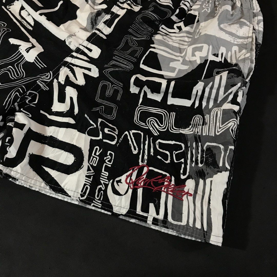 Quiksilver Graphic Swim Shorts (Category: Shorts) located in Manila. Submitted by a_aron.f6e3a7 (Listing ID 1468787140, Image 3). Description: Size: W13 L15 • Color rate: 9/10 (Black, White, and Gray All-Over Graphic Print with Red Logo Detail) • Condition: Good pre-owned condition • Issues: Visible creases and wrinkles; no obvious major holes, tears, or heavy stains.