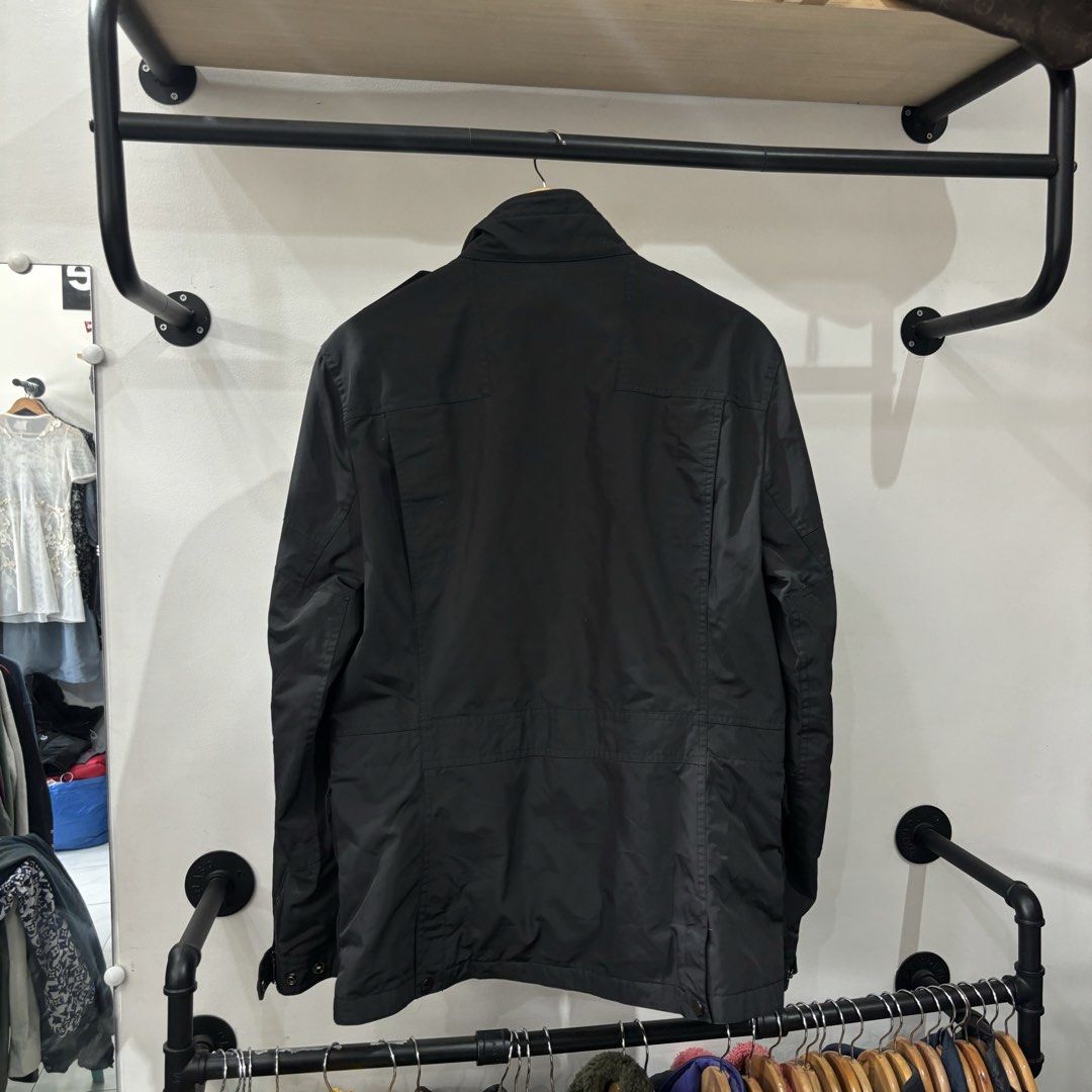 Ralph Lauren Black Utility Jacket with Multiple Pockets (Category: Coats, Jackets and Outerwear) located in Bambang. Submitted by heats777 (Listing ID 1468827917, Image 3). Description: - Brand: Ralph Lauren - Color: Black - Material: Durable nylon - Closure: Full zip front with snap button storm flap - Collar: Stand collar with shoulder epaulets - Pockets: Four front flap pockets and two vertical zippered chest pockets - Details: Branded hardwar