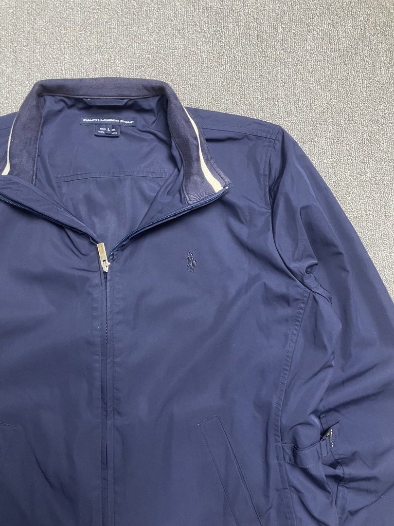 Ralph Lauren Golf Navy Zip Jacket Size L (Category: Longsleeves) located in Quezon City. Submitted by cozy_thrifting (Listing ID 1468741363, Image 2). Description: - Brand: Ralph Lauren Golf - Item: Zip-up Jacket - Color: Navy Blue - Size: Large (L) - Material: 100% Polyester - Closure: Zip front with custom branded puller tab - Collar: Ribbed with contrast piping detail - Pockets: Two front angled welt pockets - Details: Adjustable side waist ta