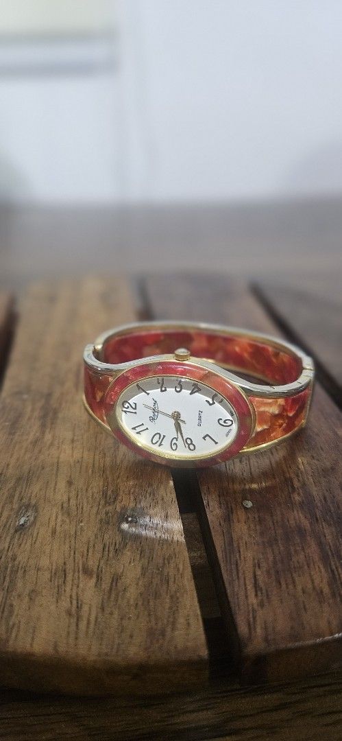 Rapport quartz bangle watch red tortoiseshell pattern (Category: Women's Watches) located in Santa Maria. Submitted by rommelmateo (Listing ID 1468859614, Image 3). Description: - Brand: Rapport - Movement: Reliable Japan quartz (battery operated) - Dial: White face with easy-to-read black Arabic numerals and gold hands - Design: Bangle-style bracelet with striking red tortoiseshell resin inlay and gold-tone metal framing - Closure: Comfortable a