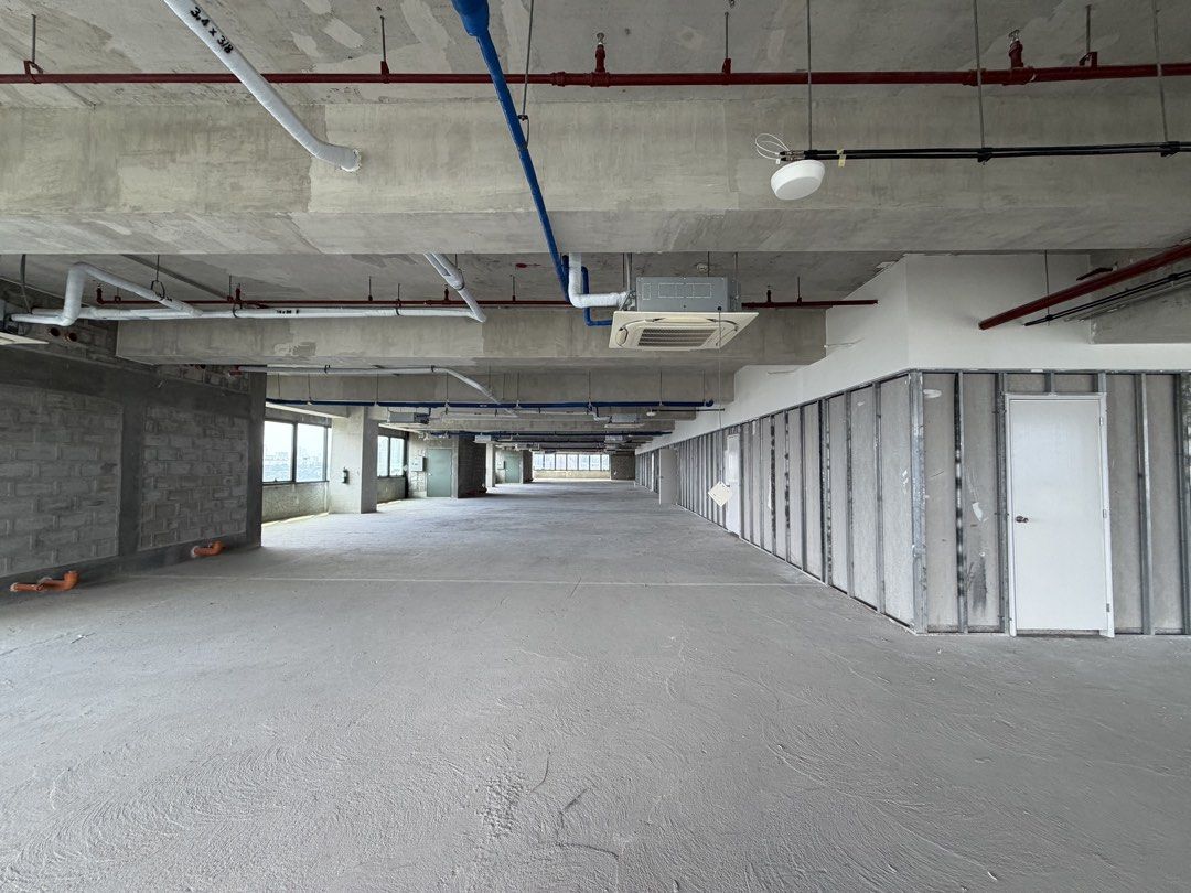 Raw Bare Shell Commercial Office Space For Lease (Category: Commercial) located in Marikina City. Submitted by jimwelllop94038 (Listing ID 1468724329, Image 2). Description: - Bare shell office floor with a raw concrete finish - Open layout featuring pre-installed partition framing on one side - High industrial ceilings with exposed pipes, ducts, and sprinklers - Abundant natural light from large perimeter windows - Includes installed ceiling AC 