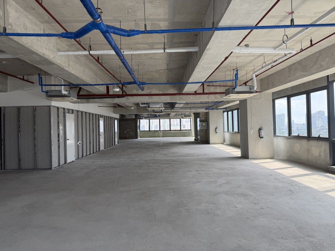 Raw Bare Shell Commercial Office Space For Lease (Category: Commercial) located in Marikina City. Submitted by jimwelllop94038 (Listing ID 1468724329, Image 1). Description: - Bare shell office floor with a raw concrete finish - Open layout featuring pre-installed partition framing on one side - High industrial ceilings with exposed pipes, ducts, and sprinklers - Abundant natural light from large perimeter windows - Includes installed ceiling AC 