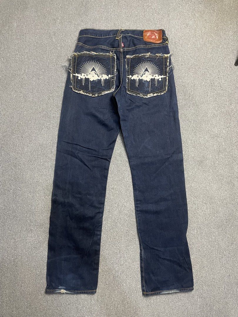 Red Monkey Company RMC Denim Jeans (Category: Jeans) located in Quezon City. Submitted by cozy_thrifting (Listing ID 1468739046, Image 2). Description: - Brand: Red Monkey Company - Material: 100% cotton raw indigo denim in dark wash - Closure: Button fly with branded copper rivets - Details: Detailed sunburst and pyramid pocket graphics with frayed edges - Features: Patterned inner pocket lining and leather back patch - Condition: Dark wash with