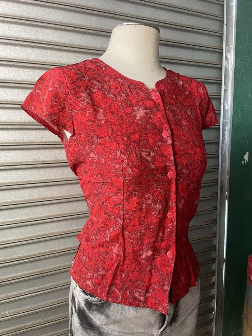 Red patterned short sleeve button-up blouse (Category: Blouses) located in Davao. Submitted by riab_qt (Listing ID 1468776786, Image 3). Description: - Color: Vibrant red with an all-over textured pattern - Fit: Fitted silhouette through the waist - Design: Front button-up closure with small pink buttons - Neckline: Scoop neck with subtle gathering near the collar - Styling: Perfect for casual outings or easy layering - Condition: Excellent, read