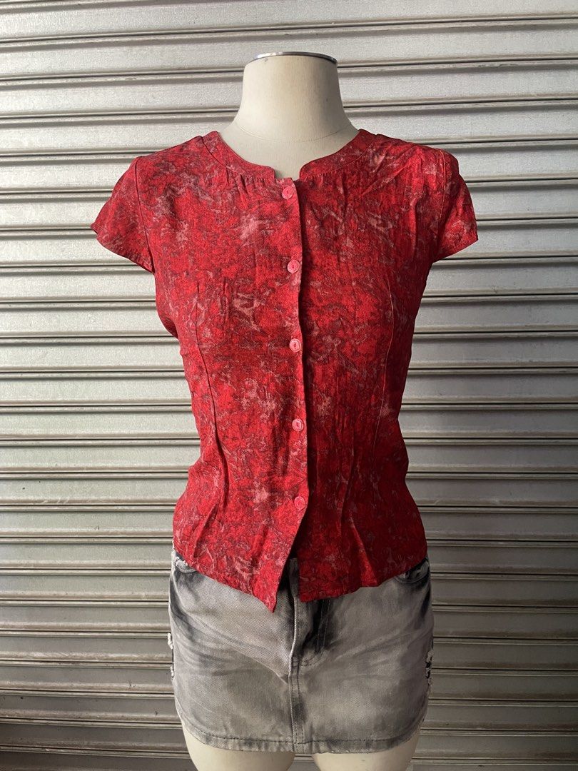 Red patterned short sleeve button-up blouse (Category: Blouses) located in Davao. Submitted by riab_qt (Listing ID 1468776786, Image 2). Description: - Color: Vibrant red with an all-over textured pattern - Fit: Fitted silhouette through the waist - Design: Front button-up closure with small pink buttons - Neckline: Scoop neck with subtle gathering near the collar - Styling: Perfect for casual outings or easy layering - Condition: Excellent, read
