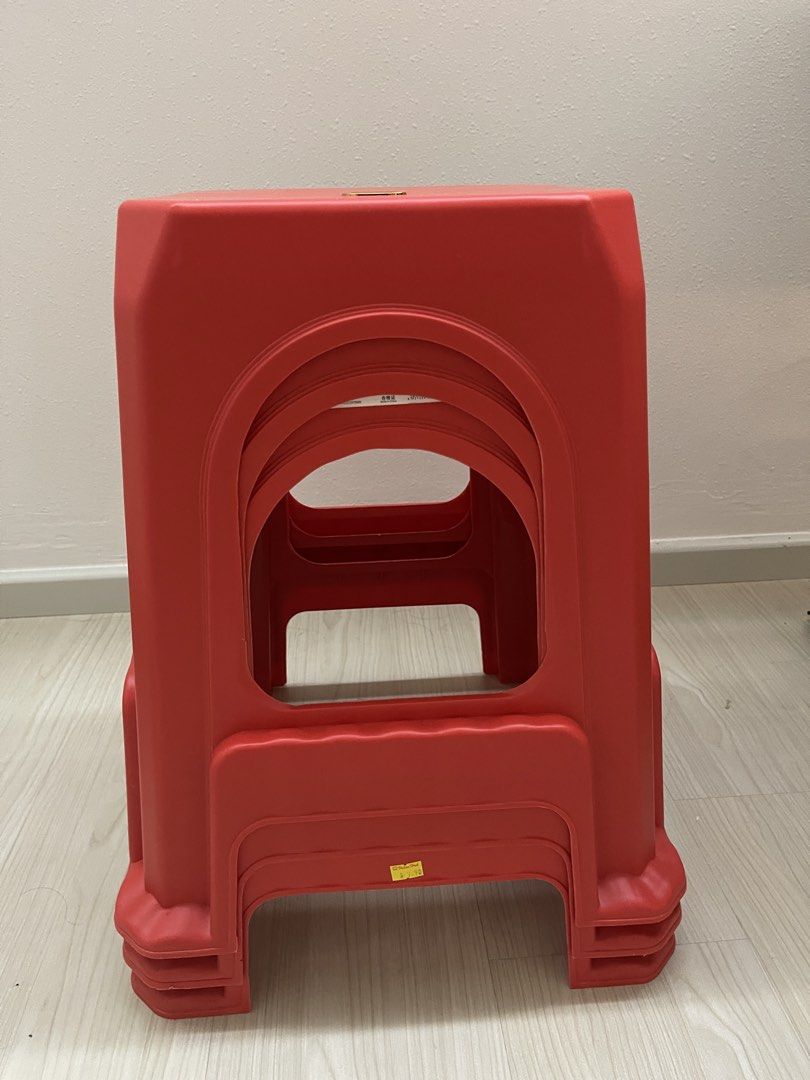 Red Plastic Stools Stackable x3 (Category: Chairs) located in Singapore. Submitted by nyopshop (Listing ID 1468906365, Image 1). Description: - Vibrant bright red plastic stools with a sturdy build and square top - Space-saving design that is easy to stack and store when not in use - Ideal for small apartments, kitchens, or providing extra seating during gatherings - Condition: Minor marks from storage on the yellow price tag area.