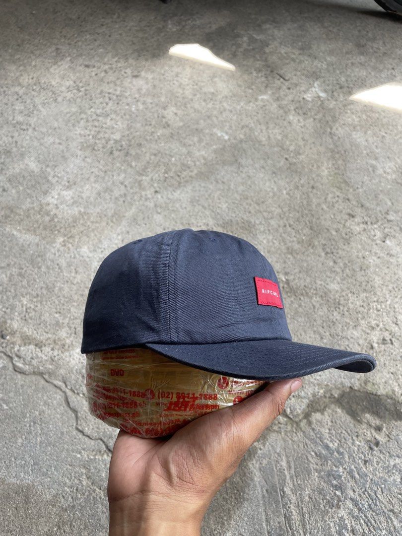 Ripcurl Navy Snapback Cap With Red Box Logo (Category: Caps & Hats) located in General Santos City (Dadiangas). Submitted by christbluee (Listing ID 1468826238, Image 3). Description: - Color: Dark navy blue - Brand: Ripcurl (The Classics Yupoong interior tag) - Design: Red rectangular patch logo with white lettering on the front - Fit: Structured crown, curved brim, and adjustable plastic snapback closure - Condition: Excellent, stylish everyday