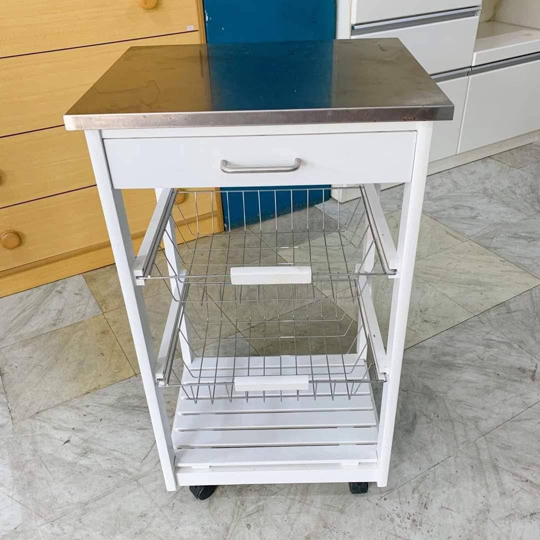 Rolling kitchen utility (Category: Bathroom & Kitchen Fixtures) located in Quezon City. Submitted by cmagday (Listing ID 1468802456, Image 1). Description: white rolling kitchen utility and serving trolley featuring a stainless steel top, a pull-out storage drawer, two wire metal vegetable baskets, a slatted bottom shelf, and caster wheels. material: White Wood & metal.