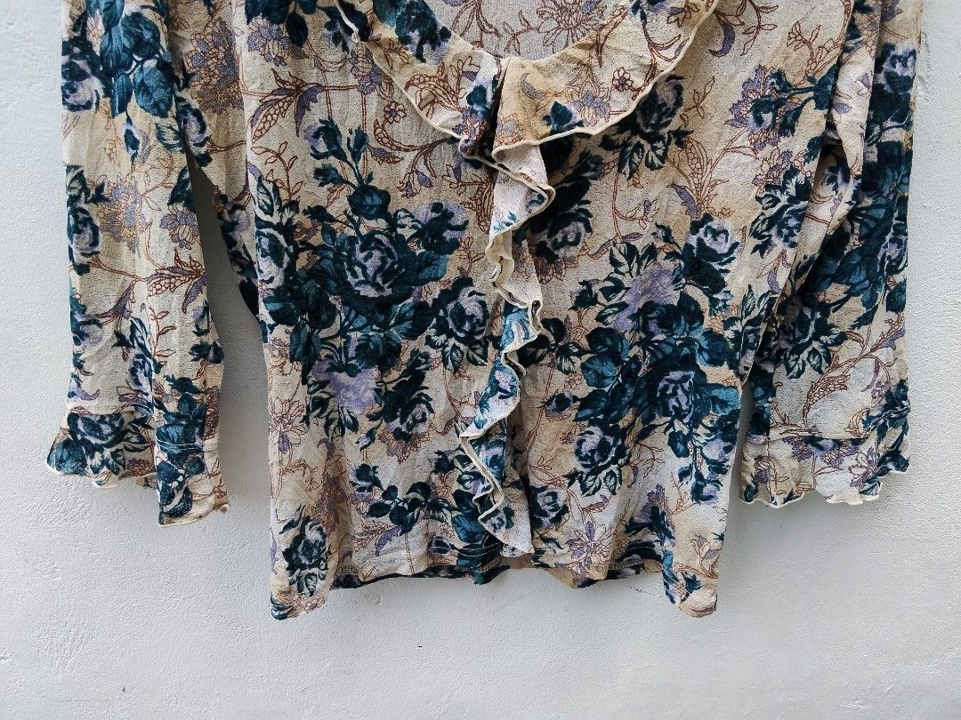 Rosa Cheri Floral Ruffle Blouse (Category: Blouses) located in City of Isabela. Submitted by jasheverything (Listing ID 1468729607, Image 3). Description: - Brand/Style: Rosa Cheri long sleeve blouse - Design: Cream background with blue and purple floral print - Details: V-neck collar with front ruffle trim and flared ruffle cuffs - Fit & Material: Lightweight, comfortable fit - Vibe: Great vintage aesthetic for casual daily wear Excellent Condit