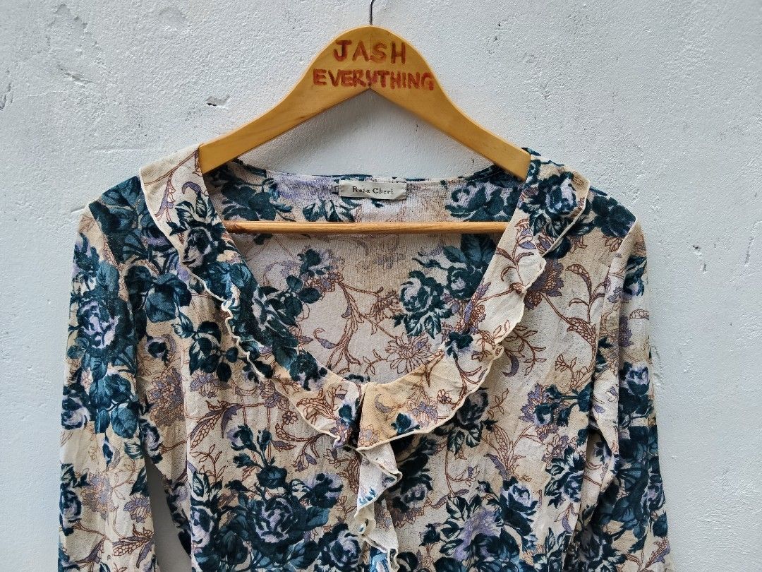 Rosa Cheri Floral Ruffle Blouse (Category: Blouses) located in City of Isabela. Submitted by jasheverything (Listing ID 1468729607, Image 2). Description: - Brand/Style: Rosa Cheri long sleeve blouse - Design: Cream background with blue and purple floral print - Details: V-neck collar with front ruffle trim and flared ruffle cuffs - Fit & Material: Lightweight, comfortable fit - Vibe: Great vintage aesthetic for casual daily wear Excellent Condit