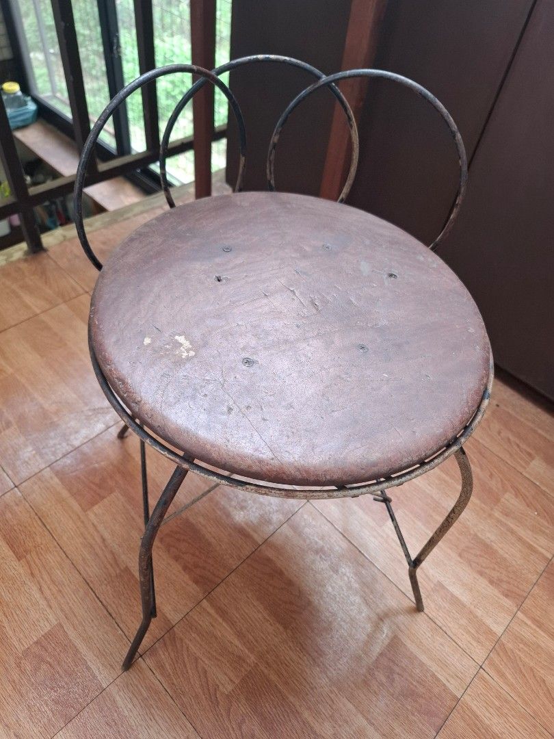 Round Wooden Chair (Category: Chairs) located in Marikina City. Submitted by msmhmsjijbmh (Listing ID 1468761286, Image 1). Description: - Type: Round wooden stool with metal frame - Design: Weathered finish, slender curved legs, and a distinctive 3-ring wire backrest - Condition: Shows charming signs of wear and age on both wood and metal - Build: Sturdy, durable, and practical - Best Use: Ideal for a study desk, vanity, or casual dining space -