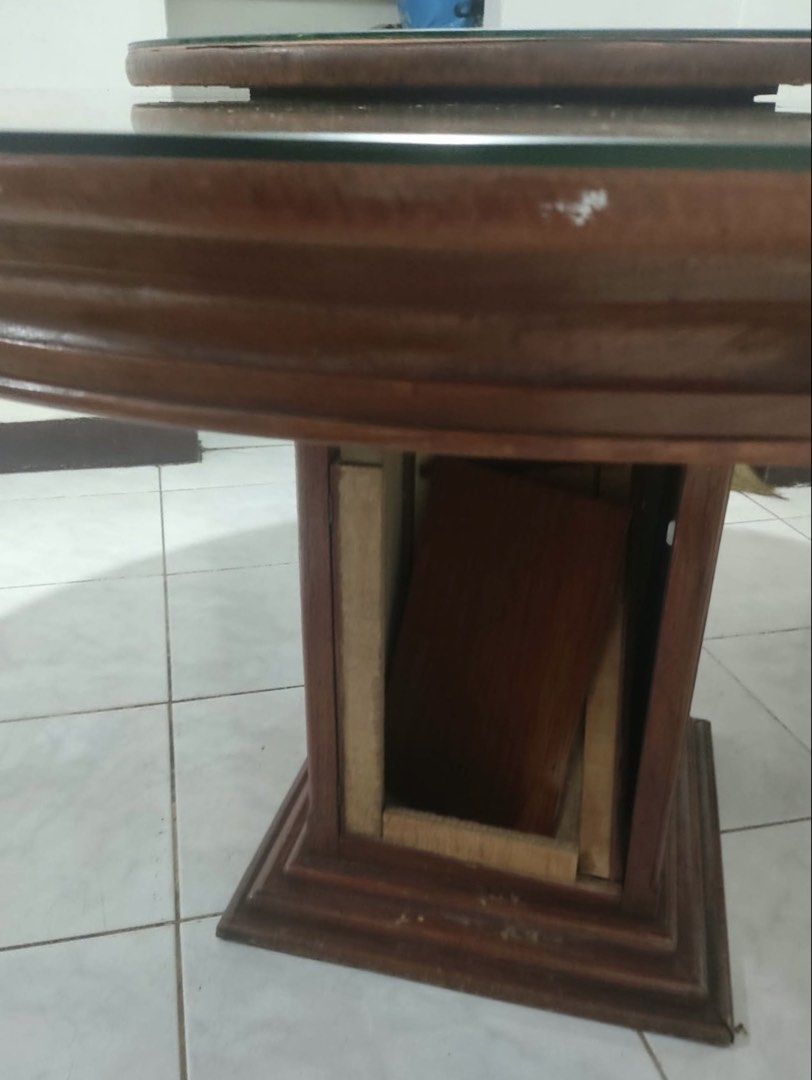 Round wooden dining table with lazy susan (Category: Tables & Sets) located in Manila. Submitted by rei26mars (Listing ID 1468822034, Image 2). Description: - Round wooden dining table with a built-in lazy susan - Rich wood grain finish throughout - Sturdy pedestal base - Condition: Has structural damage, missing side panels underneath, surface scratches, wear, and edge chipping - Ideal DIY restoration project for handy buyers - Selling as-is.