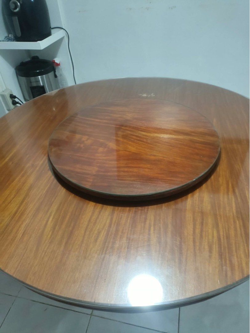 Round wooden dining table with lazy susan (Category: Tables & Sets) located in Manila. Submitted by rei26mars (Listing ID 1468822034, Image 1). Description: - Round wooden dining table with a built-in lazy susan - Rich wood grain finish throughout - Sturdy pedestal base - Condition: Has structural damage, missing side panels underneath, surface scratches, wear, and edge chipping - Ideal DIY restoration project for handy buyers - Selling as-is.