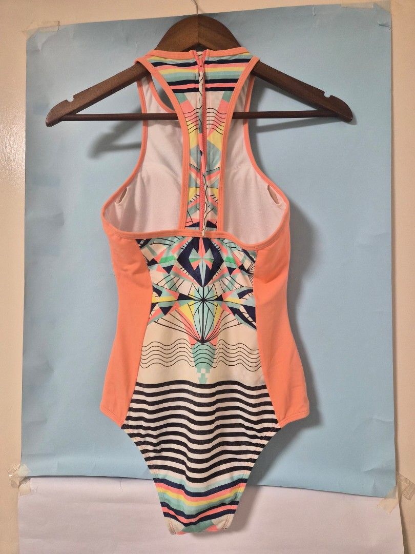 Roxy One-Piece Swimsuit Geometric Print (Category: Bikinis & Swimsuits) located in Manila. Submitted by prelovedbyc.hannah (Listing ID 1468783747, Image 2). Description: - Brand: Roxy - Style: One-piece swimsuit - Design: Geometric front with peach side panels and black/white stripes on the right hip - Back Details: Sporty racerback with convenient zipper closure - Comfort: Built-in white lining - Ideal For: Beach days, pool parties, and vacation