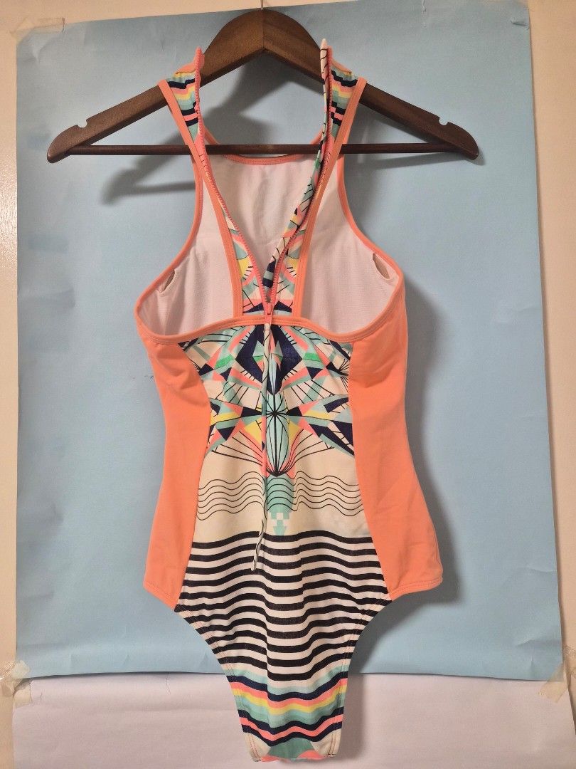 Roxy One-Piece Swimsuit Geometric Print (Category: Bikinis & Swimsuits) located in Manila. Submitted by prelovedbyc.hannah (Listing ID 1468783747, Image 3). Description: - Brand: Roxy - Style: One-piece swimsuit - Design: Geometric front with peach side panels and black/white stripes on the right hip - Back Details: Sporty racerback with convenient zipper closure - Comfort: Built-in white lining - Ideal For: Beach days, pool parties, and vacation
