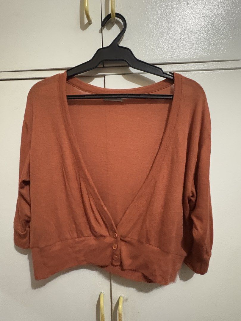 Rust Cropped Cardigan Sweater 3/4 Sleeves (Category: Coats, Jackets and Outerwear) located in Bulacan. Submitted by hey_alyyy (Listing ID 1468717908, Image 2). Description: - Color: Rust - Style: Cropped cardigan with deep V-neckline - Sleeves: 3/4 length - Details: Three functional buttons at the front hem - Material: Soft, lightweight knit fabric - Versatility: Great for layering over dresses, sleeveless tops, tank top, bralette, high-waist den