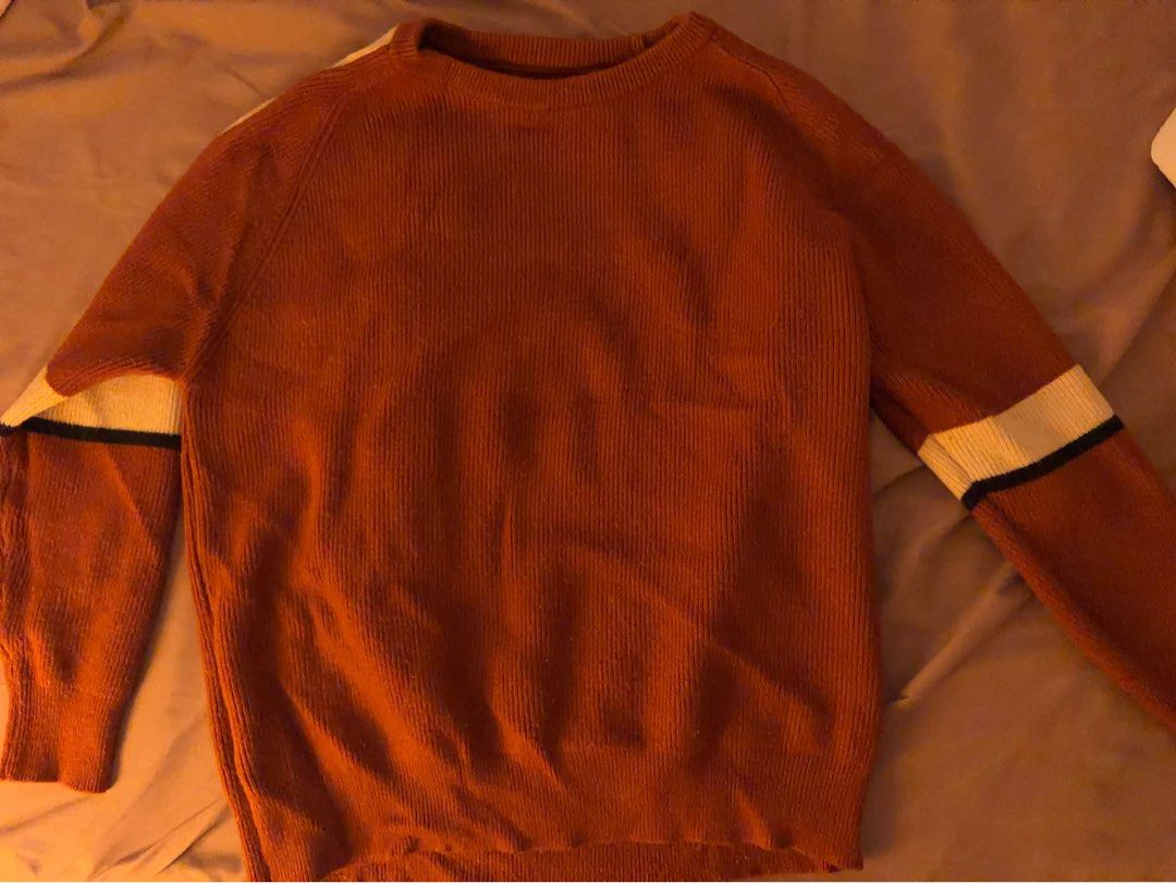 Rust orange knit sweater with sleeve stripes (Category: Coats, Jackets and Outerwear) located in Antipolo. Submitted by faithforgotten (Listing ID 1468725880, Image 1). Description: - Color: Rust orange with cream and black sleeve stripes - Material: Soft, warm, and comfortable knit - Design: Classic crew neckline and ribbed texture - Fit: Relaxed pullover style - Styling: Perfect for cooler days and easy to match with casual pants or jeans.