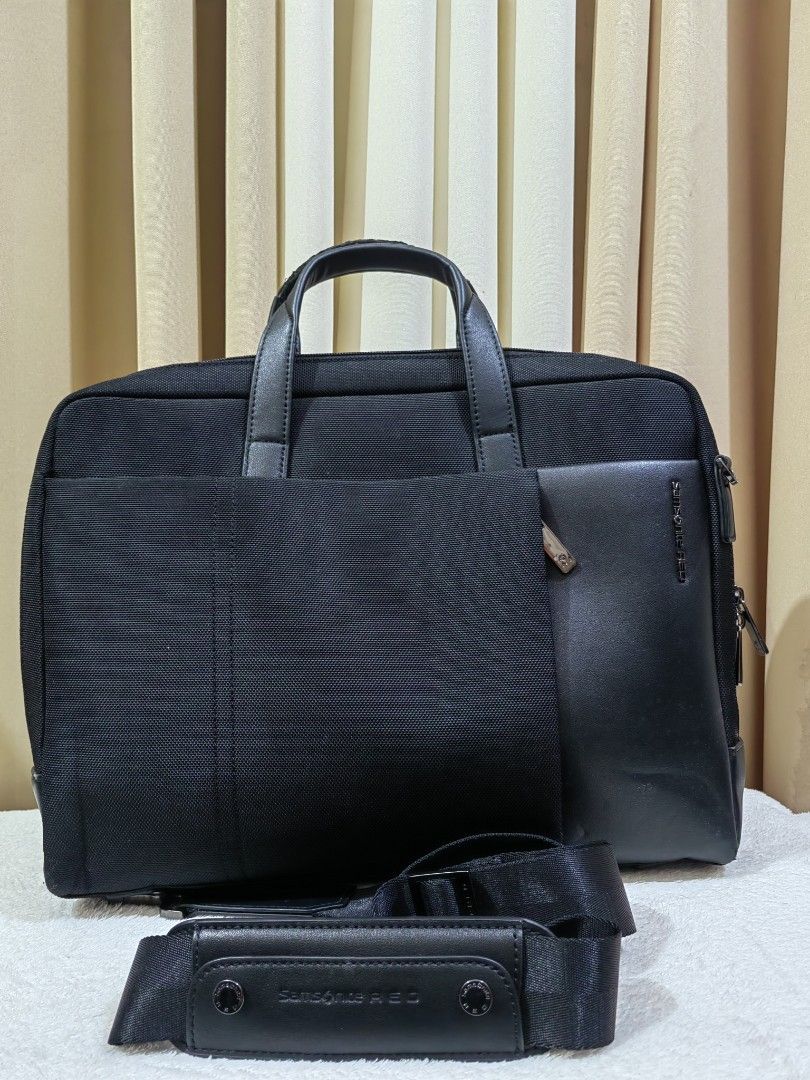 Samsonite RED black briefcase laptop bag (Category: Briefcases) located in Makati City. Submitted by prelovedtreatedwithlove (Listing ID 1468880925, Image 1). Description: - Brand: Samsonite RED - Color: Black - Material: Durable nylon canvas and faux leather - Carry options: Dual top handles and detachable shoulder strap - Laptop protection: Padded interior sleeve with security strap - Storage: Multiple internal compartments and front magnetic p