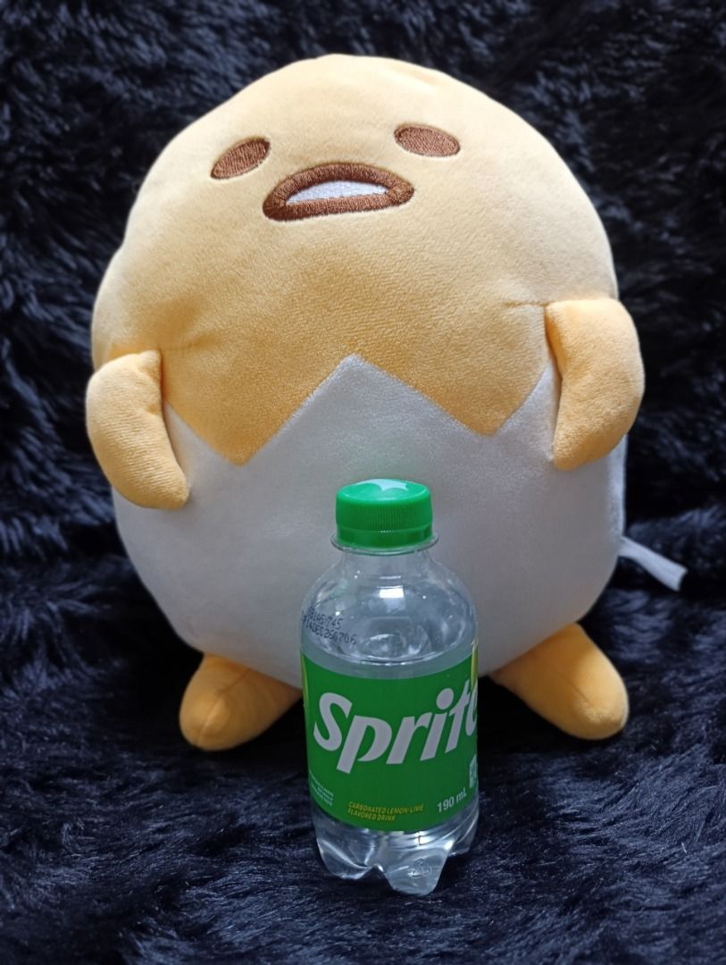 Sanrio Gudetama Egg Shell Plush Toy (Category: Plushies & Soft Toys) located in Iloilo. Submitted by jpk_ok_sales (Listing ID 1468798653, Image 1). Description: - Authentic Sanrio Gudetama plush toy featuring the lazy egg inside a cracked white eggshell - Features detailed embroidered facial expression on top - Made with ultra-soft, huggable plush material - Size reference: Shown next to a 190ml Sprite bottle (bottle not included) - Condition: Cl