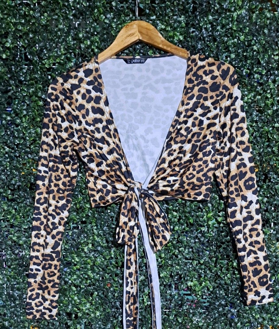 SHEIN Leopard Print Tie Front Long Sleeve Crop Top (Category: Longsleeves) located in Batangas. Submitted by yanaspreloved1 (Listing ID 1468924312, Image 2). Description: - Brand: SHEIN - Design: Leopard print crop top with deep V-neckline and long sleeves - Closure: Self-tie wrap closure at the bottom - Material: Stretchy and comfortable fabric - Condition: Excellent Condition -No accessories included .