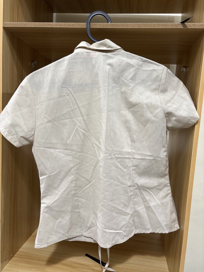 Short sleeve button up shirt cream (Category: Shirts) located in Manila. Submitted by krinpet (Listing ID 1468856592, Image 2). Description: Cream short sleeve button-up shirt in a lightweight, linen-like fabric. Features a pleated front panel, thin hem drawstrings, classic collar, and a fitted cut with front and back darts. A versatile neutral piece that easily matches any outfit..