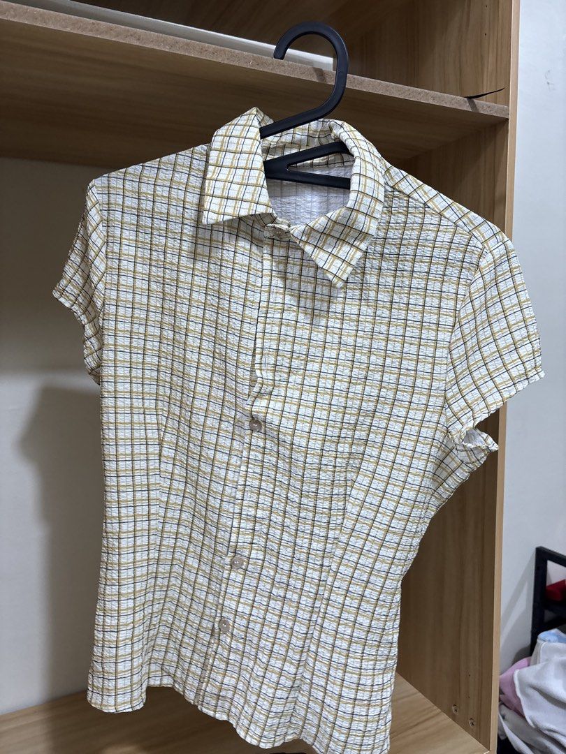 Short sleeve plaid collared button up blouse (Category: Blouses) located in Manila. Submitted by krinpet (Listing ID 1468858573, Image 1). Description: - Color/Pattern: Yellow and dark grey plaid on white background - Material: Lightweight and textured seersucker fabric - Design: Short sleeves, classic lapel collar, and button-down front - Special Detail: Stylish knotted back for a cinched waist silhouette - Fit: True to size, great for casual ev
