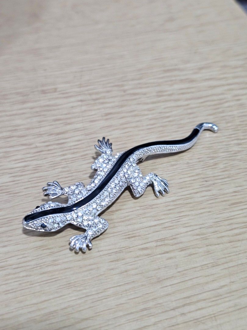 Silver and Black Gecko Lizard Rhinestone Brooch Pin (Category: Brooches) located in Caloocan City. Submitted by smart_shoppers_ville (Listing ID 1468806699, Image 1). Description: - Dual-purpose design: works as both a brooch pin and a pendant necklace charm - Eye-catching silver-tone metal with glittering rhinestones and a bold black stripe - Features detailed feet and a textured body for a realistic look - Decent size that stands out perfectly 