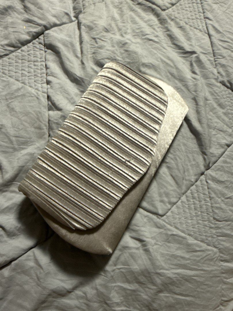 Silver Pleated Evening Clutch Bag with Chain Strap (Category: Clutches) located in Caloocan City. Submitted by tootsief (Listing ID 1468864891, Image 1). Description: - Color: Elegant silver - Design: Stylish pleated flap on the front with a smooth satin-like finish on the back - Closure: Secure magnetic snap - Interior: Clean lining with a convenient slip pocket - Strap: Includes a small detachable silver chain strap (still sealed in original pl