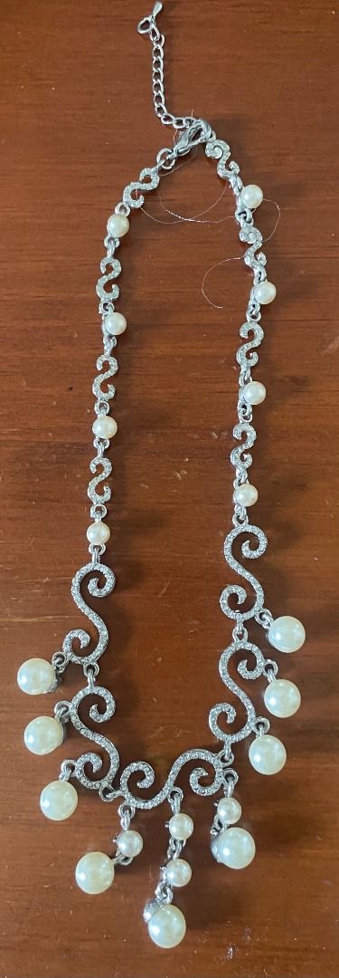 Silver Rhinestone Pearl Drop Statement Necklace (Category: Necklaces) located in Pasig City. Submitted by didi.0514 (Listing ID 1468750996, Image 1). Description: - Silver-tone statement necklace with sparkling rhinestones and dangling faux pearls - Beautiful and intricate filigree swirl drop design - Adjustable chain closure with a secure lobster clasp - Ideal for weddings, parties, and formal events - Elegant.
