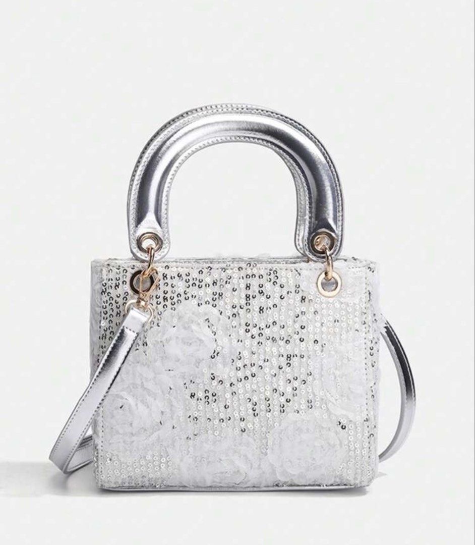 Silver Sequin Mini Handbag with Crossbody Strap S Size (Category: Babies & Kids Fashion) located in Santo Tomas. Submitted by kylejao21 (Listing ID 1468878475, Image 1). Description: - Stunning silver mini handbag covered in sequins and delicate white floral details - Chic gold-toned hardware with a metallic top handle and matching shoulder strap - Compact dimensions: approx. 13cm (L) x 12cm (H) x 6.5cm (W) - Surprisingly spacious: easily fits yo