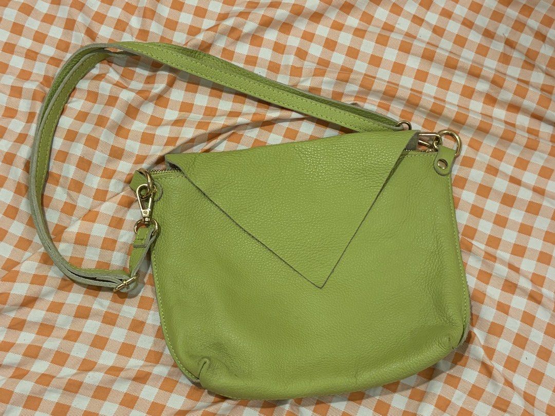 SMX Green Leather Crossbody Bag (Category: Cross-body Bags) located in Manila. Submitted by jdace (Listing ID 1468846166, Image 1). Description: - Brand: SMX - Material: 100% real pebbled leather (Made in Italy) - Color: Bright lime green - Design: Triangular front pocket with zipper closure - Hardware: Gold-tone accents with an adjustable long strap - Interior: Dark lining with an extra zippered pocket.