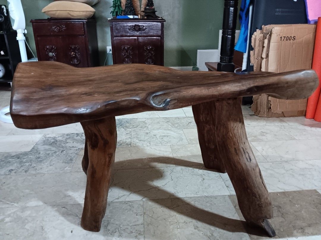 Solid wood live edge bench or coffee table (Category: Chairs) located in Las Pinas. Submitted by jesus1smysavi0r (Listing ID 1468730589, Image 1). Description: - Material: Solid wood with rich brown finish - Design: Unique live edge top with organic branch legs - Structure: Sturdy three-leg design - Finish: Smooth polished surface showing natural contours and knots - Versatility: Perfect rustic accent piece for any room in the house.