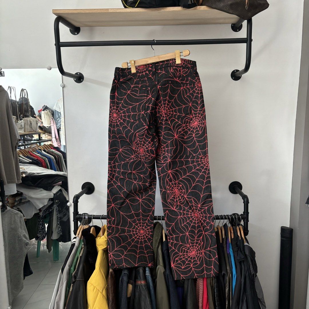 Sp5der Spider Web Print Black Denim Jeans Sample Size L (Category: Jeans) located in Bambang. Submitted by heats777 (Listing ID 1468820890, Image 3). Description: - Brand: Sp5der Worldwide - Size: L (Tag still attached) - Color/Design: Black denim with all-over red spider web print - Fit: Wide straight leg cut with classic 5-pocket styling - Material: Solid, heavyweight denim - Details: Branded hardware on button.