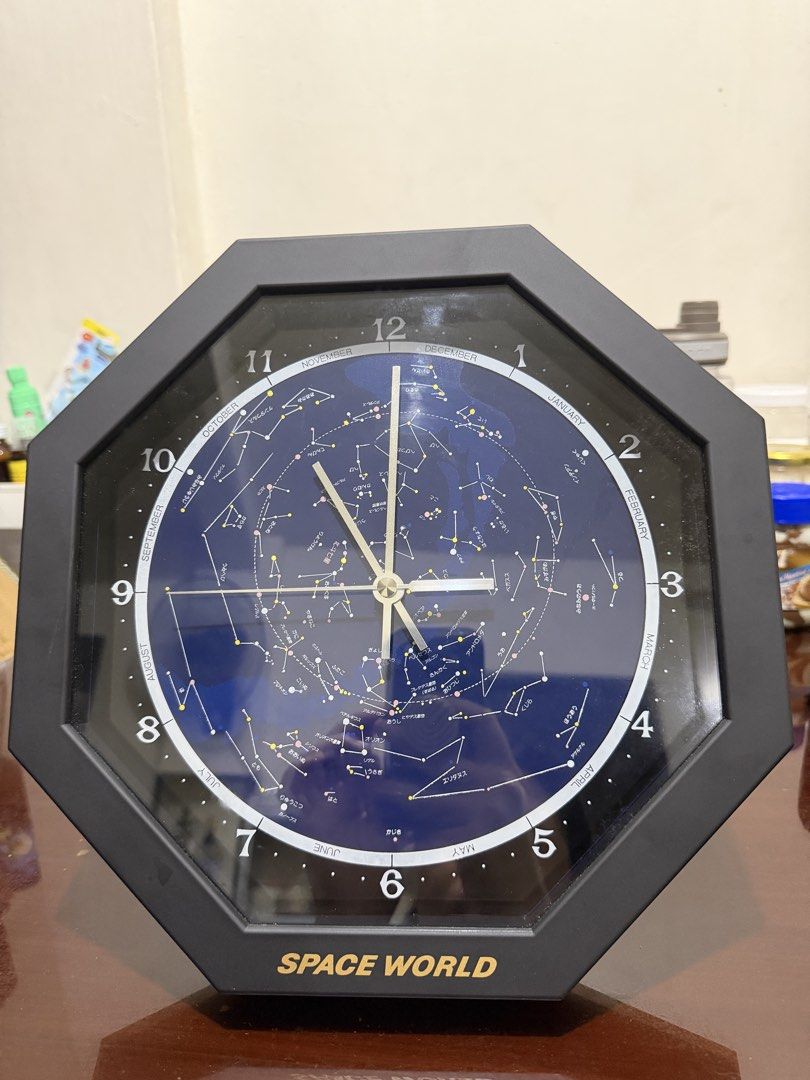 Space World Constellation Wall Clock (Category: Clocks) located in Manila. Submitted by ajdfinds (Listing ID 1468873161, Image 1). Description: - Brand: Space World - Design: Blue constellation face with printed month markers and star maps inside a sleek black octagonal frame - Movement: Made-in-Japan quartz movement for accurate timekeeping - Power Source: Uses 1 x AA battery - Condition: Works great and keeps precise time.