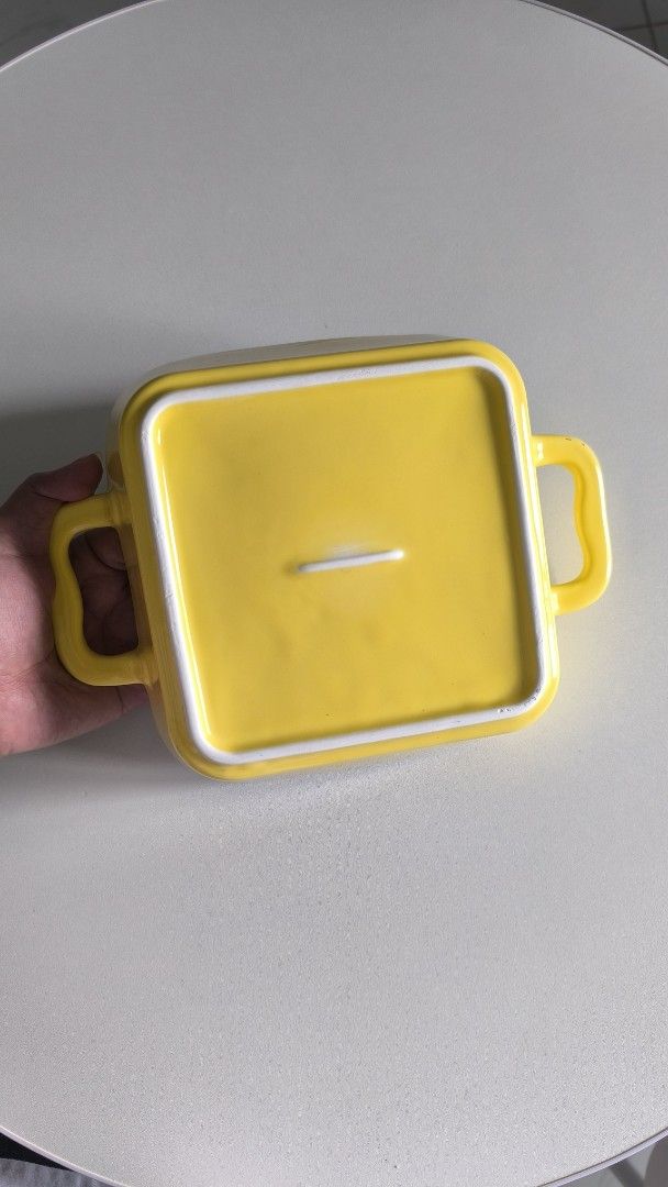 Square ceramic baking dish with yellow handles (Category: Bakeware) located in Manila. Submitted by tinebellen (Listing ID 1468743286, Image 3). Description: - Type: Square baking dish - Color: White with bright yellow handles - Material: Thick ceramic - Ideal for: Small casseroles or single servings - Condition: Used a couple of times, still in great shape (no chips or cracks) - Features: Handy side handles for safe and easy oven removal Japan S