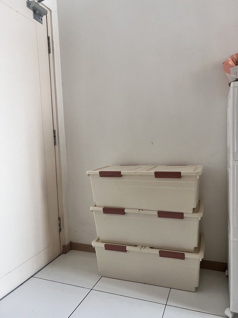Stackable plastic storage boxes with lids (Category: Storage Boxes & Baskets) located in Shah Alam. Submitted by atiraasalleh (Listing ID 1468756685, Image 2). Description: - Set of 3 sturdy beige plastic storage boxes - Secure brown latch clips on both ends of the lids - Rectangular design ideal for closets, garages, or bedrooms - Sold as a complete set of three.