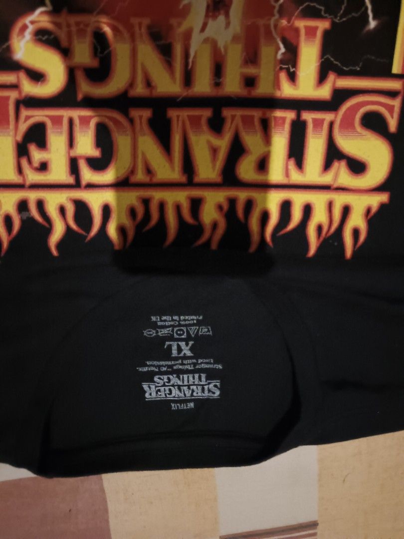 Stranger thing graphic tee (Category: Activewear) located in Odiongan. Submitted by thriftngo26 (Listing ID 1468843872, Image 2). Description: The image features an official Stranger Things Season 4 graphic t-shirt showcasing the character Eddie Munson shredding his guitar on top of a trailer in the Upside Down, surrounded by a dramatic hellfire landscape and lightning strikes..