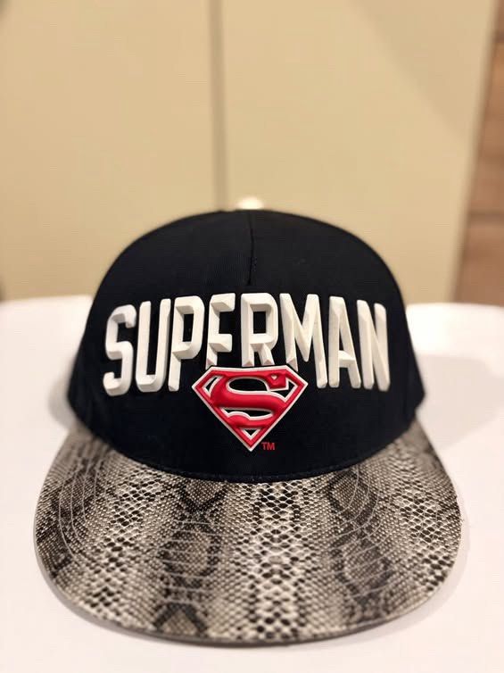 Superman DC Comics Snapback Cap Snake Print Brim (Category: Caps & Hats) located in Cebu City. Submitted by ubecstoned (Listing ID 1468821715, Image 1). Description: - Official DC Comics / Warner Bros. merchandise - Color: Black with grey snake print flat brim - Front: Raised white lettering with red Superman logo - Back: DC embroidered logo and adjustable strap with Warner Bros. red tag - Interior: Branded tape and Superman tag, extremely clean 